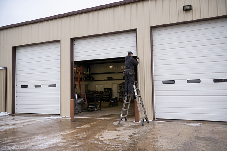 GCommercial garage door repair technician fixing overhead door
